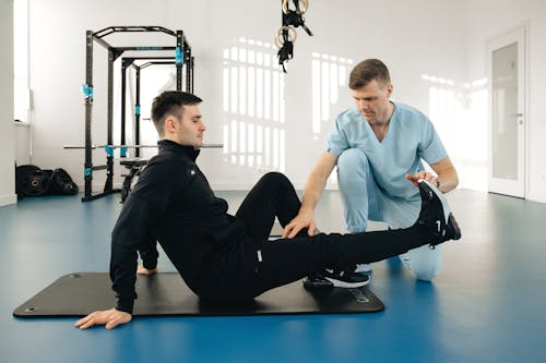 Free A man doing exercises on a mat with a doctor Stock Photo