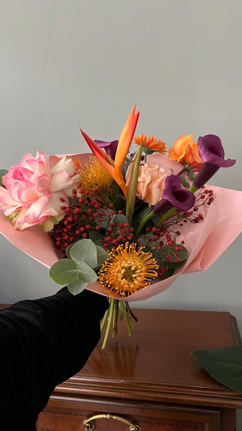 A person holding a bouquet of flowers in their hand