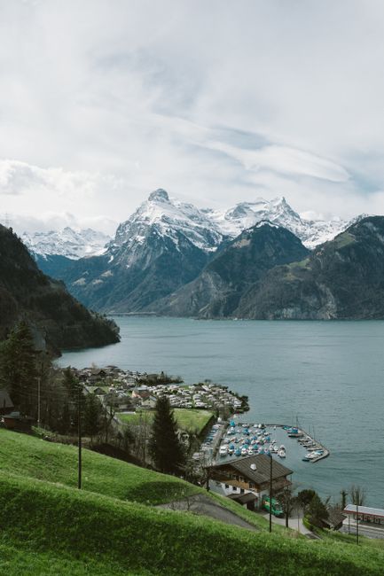Beautiful view of a marina by a lake surrounded by snow-capped mountains in the Alps.