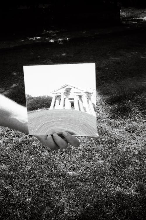 A person holding a photo of a building