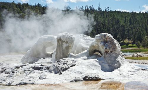 Free A captivating geyser formation steaming in Yellowstone National Park's scenic landscape. Stock Photo