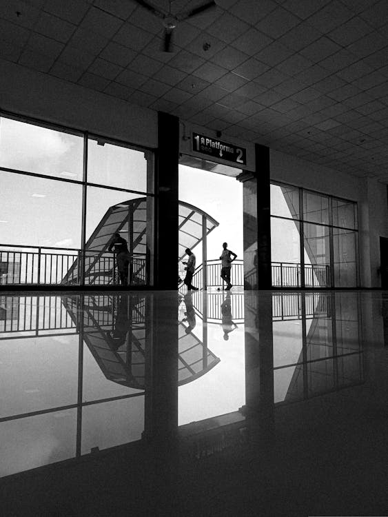 A black and white photo of people walking through an airport