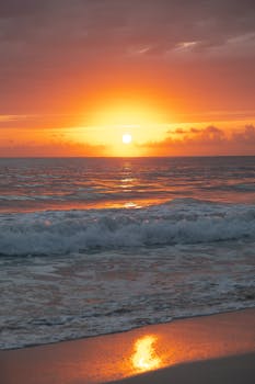 Captivating sunset at Punta Cana, Dominican Republic, with waves gently lapping the sandy shore.