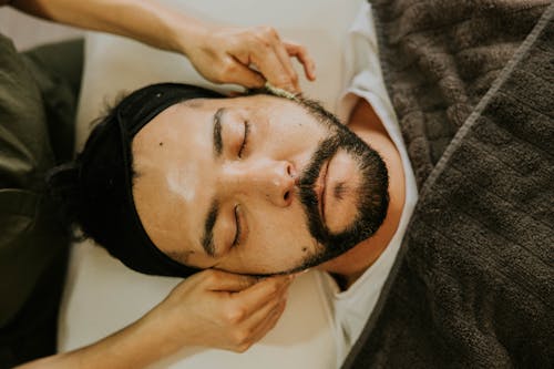 A man getting a facial massage in a spa