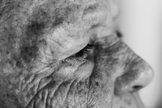 Detailed black and white side profile of an elderly person's wrinkles and eye.