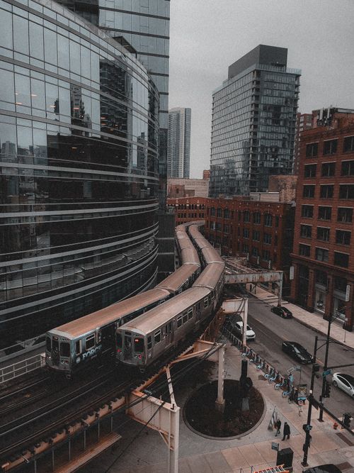 Free Drone shot capturing train tracks winding through Chicago's downtown skyscrapers. Stock Photo