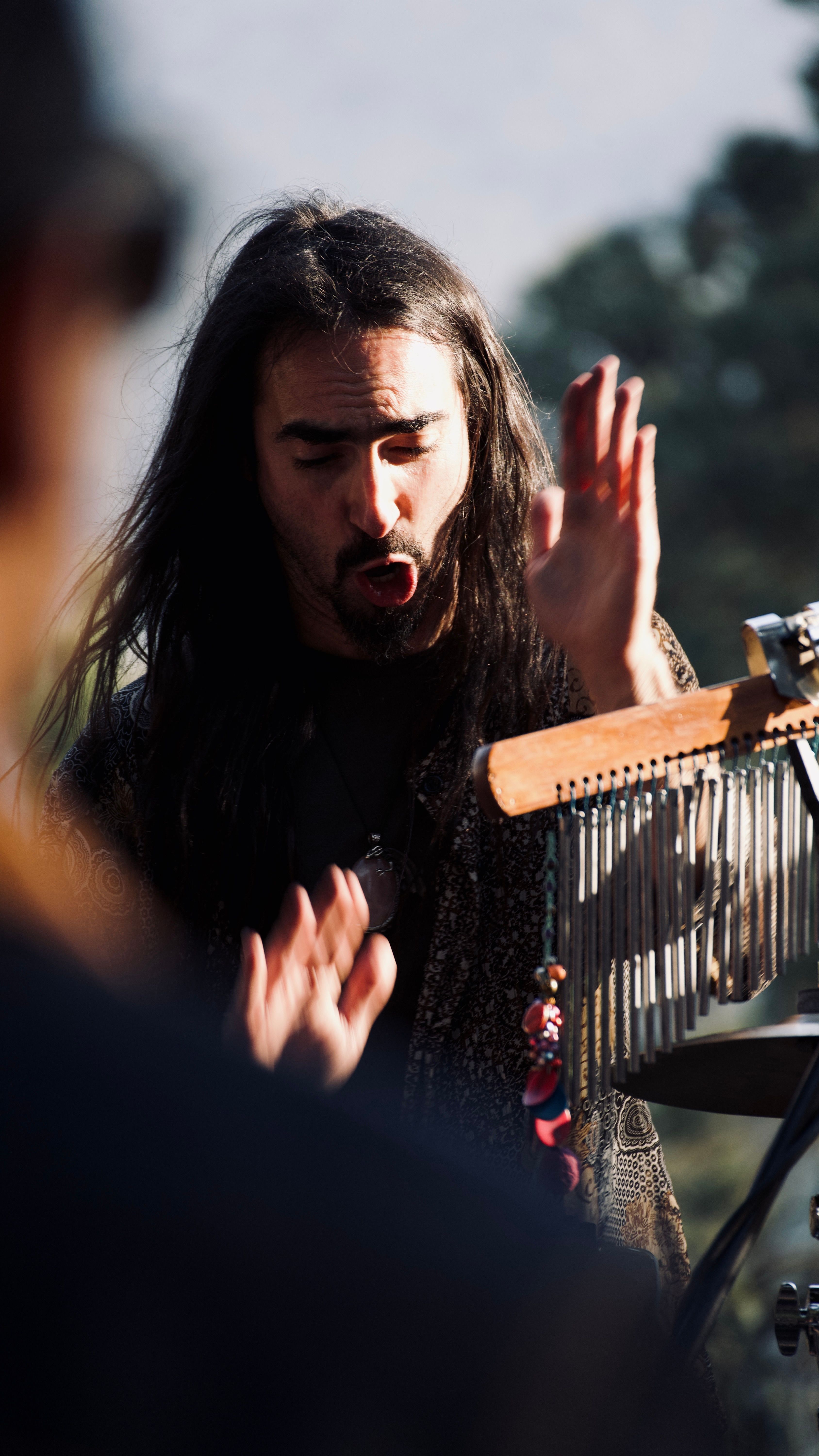 A man with long hair playing a musical instrument · Free Stock Photo