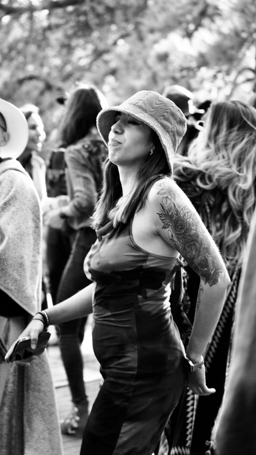 Free Black and white image of a woman joyfully dancing at an outdoor festival. Stock Photo