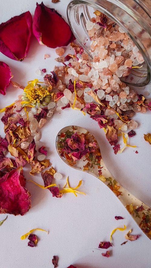 Free Aromatic setup featuring spilled salt crystals, flower petals, and a spoon, perfect for relaxation settings. Stock Photo