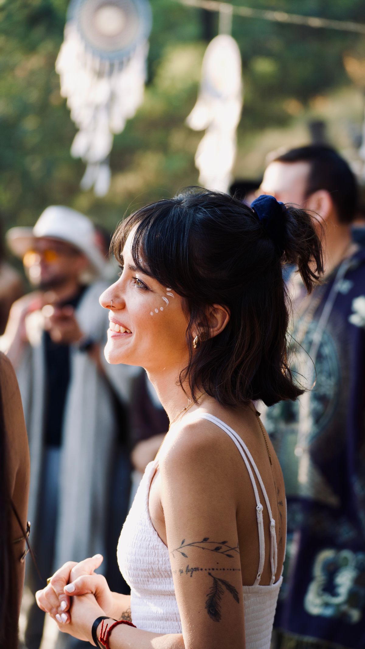 Woman smiling at a festival in a flowing white dress Woman smiling at a festival in a flowing white dress