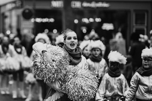 A woman in a parade with pom poms
