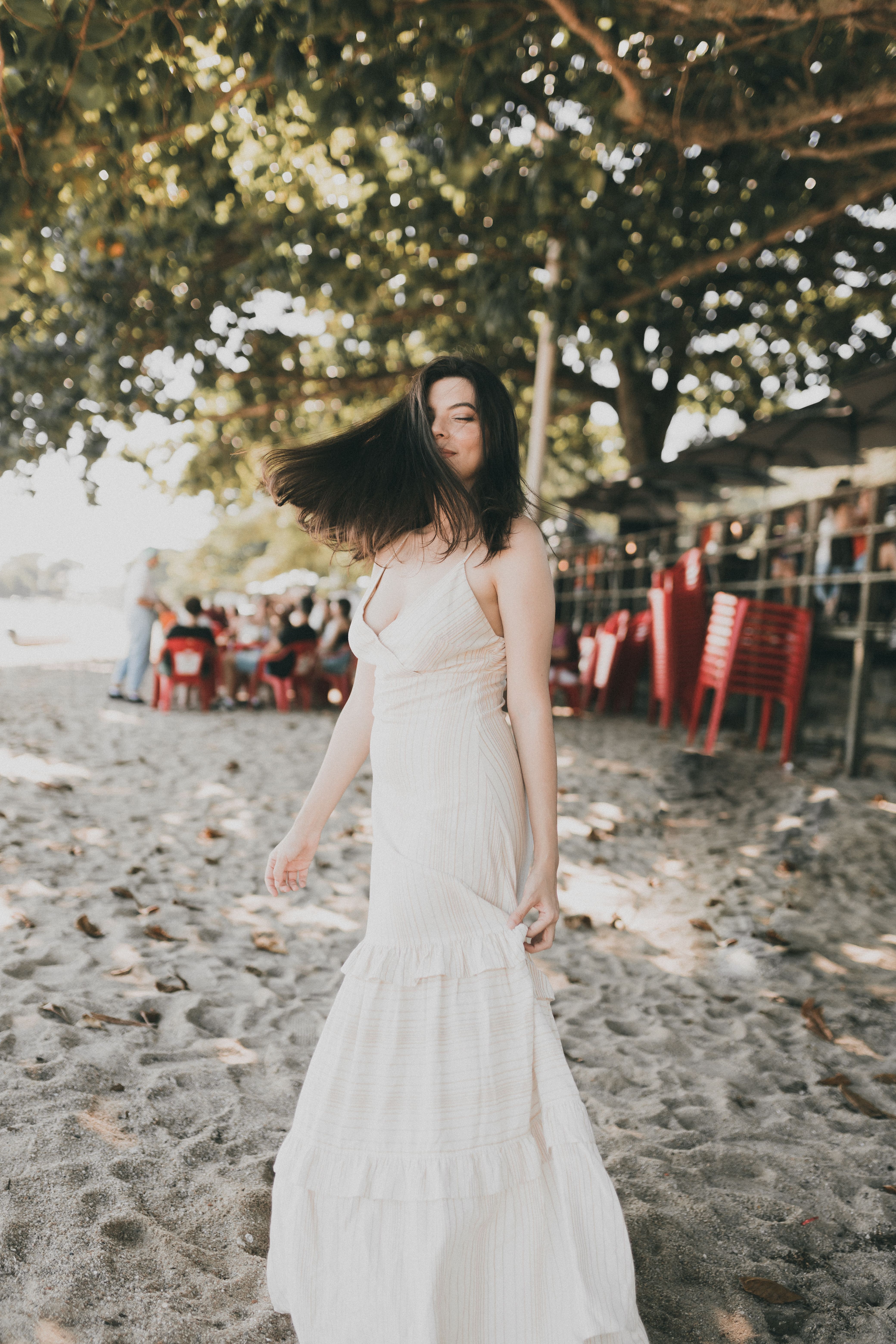 Beautiful Brunette Woman in White Dress Posing on Beach · Free Stock Photo