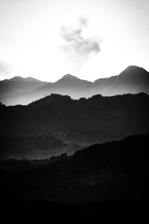 Free Dramatic black and white photo of misty hills and mountains shrouded in fog. Stock Photo