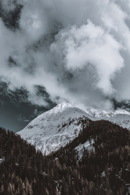 Foto De Montanha Coberta De Neve Sob Céu Nublado