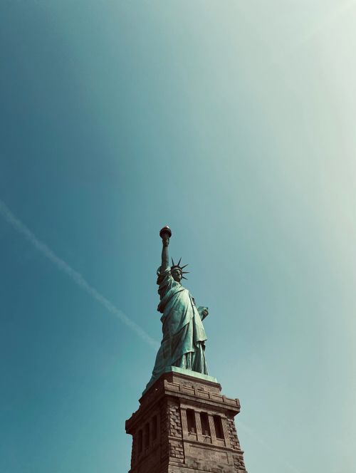Free Iconic Statue of Liberty set against a clear sky, symbolizing freedom in New York City. Stock Photo