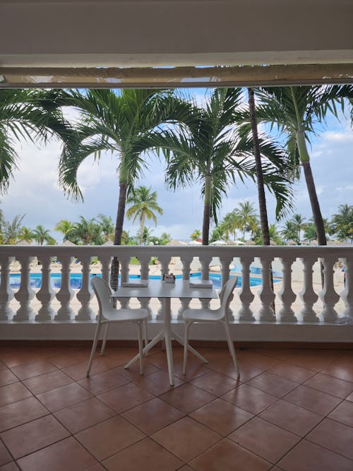 Free A balcony with chairs and a table overlooking the pool Stock Photo