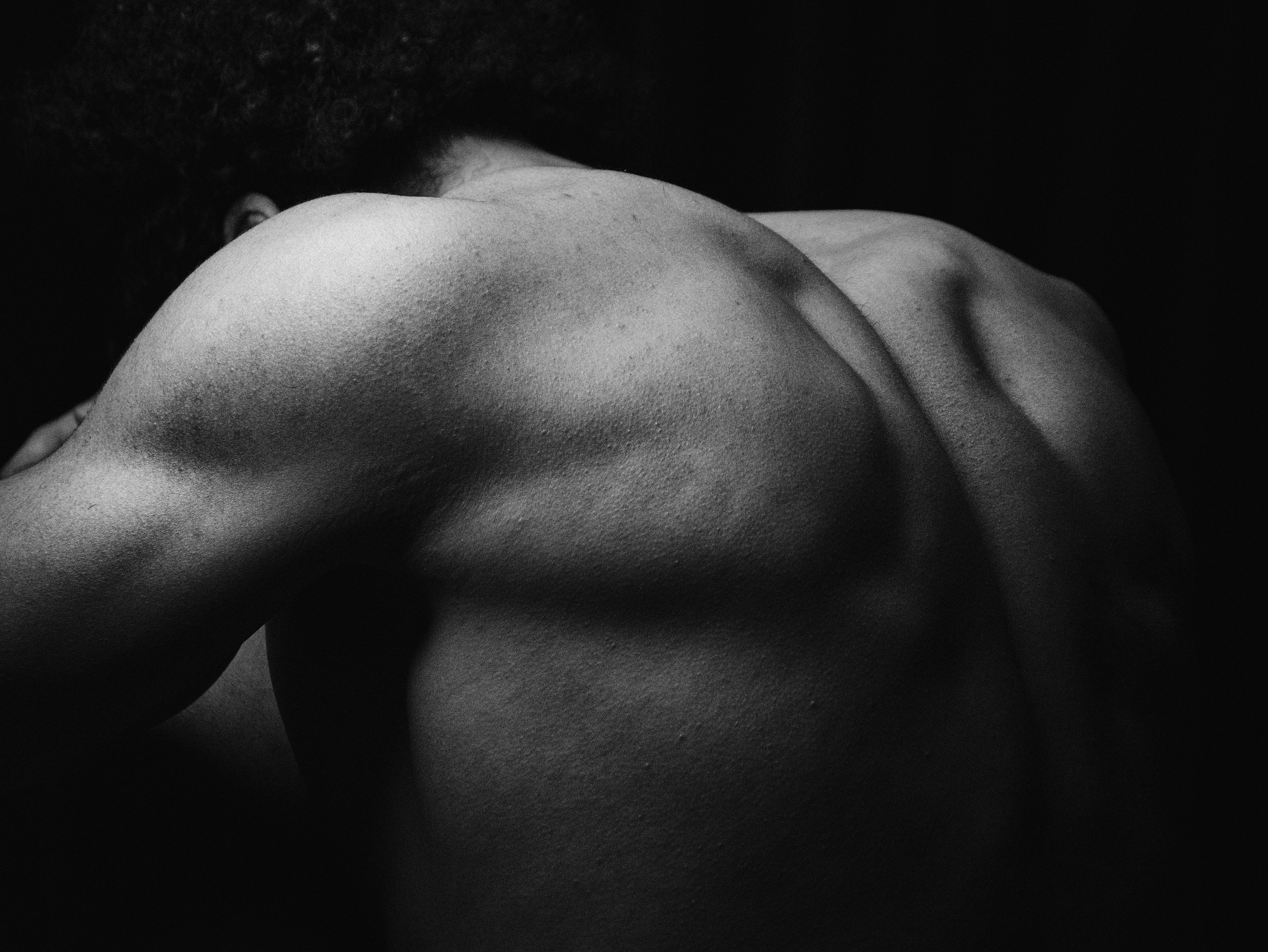 Artistic study of a back and shoulder in dramatic light — photo by Yousef Morsi on Pexels