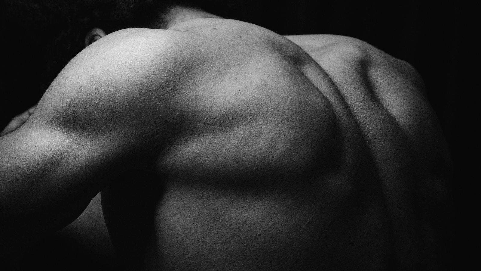 Artistic study of a back and shoulder in dramatic light — photo by Yousef Morsi on Pexels