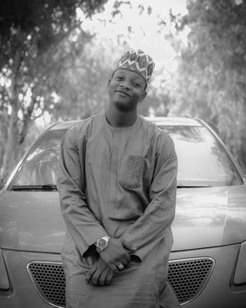 A man in a crown sitting on a car