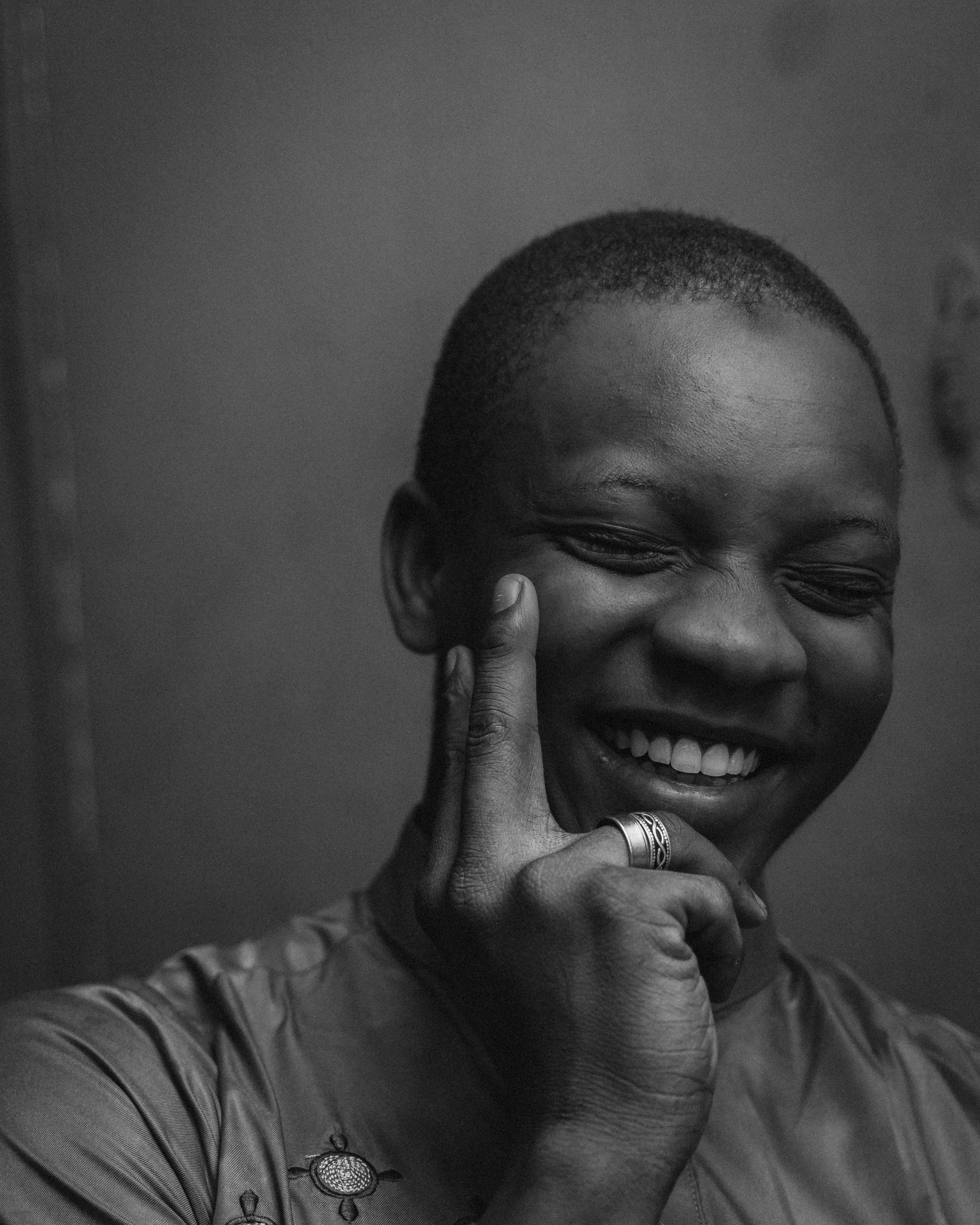 Joyful black and white portrait of a man smiling with eyes closed, evoking happiness and warmth.