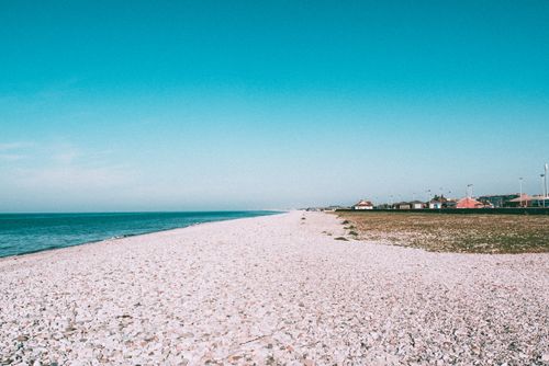 Free Explore the serene pebble beach at Abergele, Wales, under a clear blue sky. Perfect vacation spot. Stock Photo