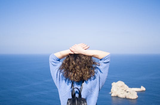 Woman in blue sweater enjoying a sea view at Sant Antoni de Portmany, Ibiza.
