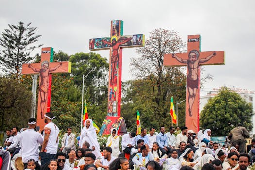 A vibrant crowd gathers in Addis Ababa, Ethiopia, celebrating the Meskel Festival with decorated crosses and national flags.