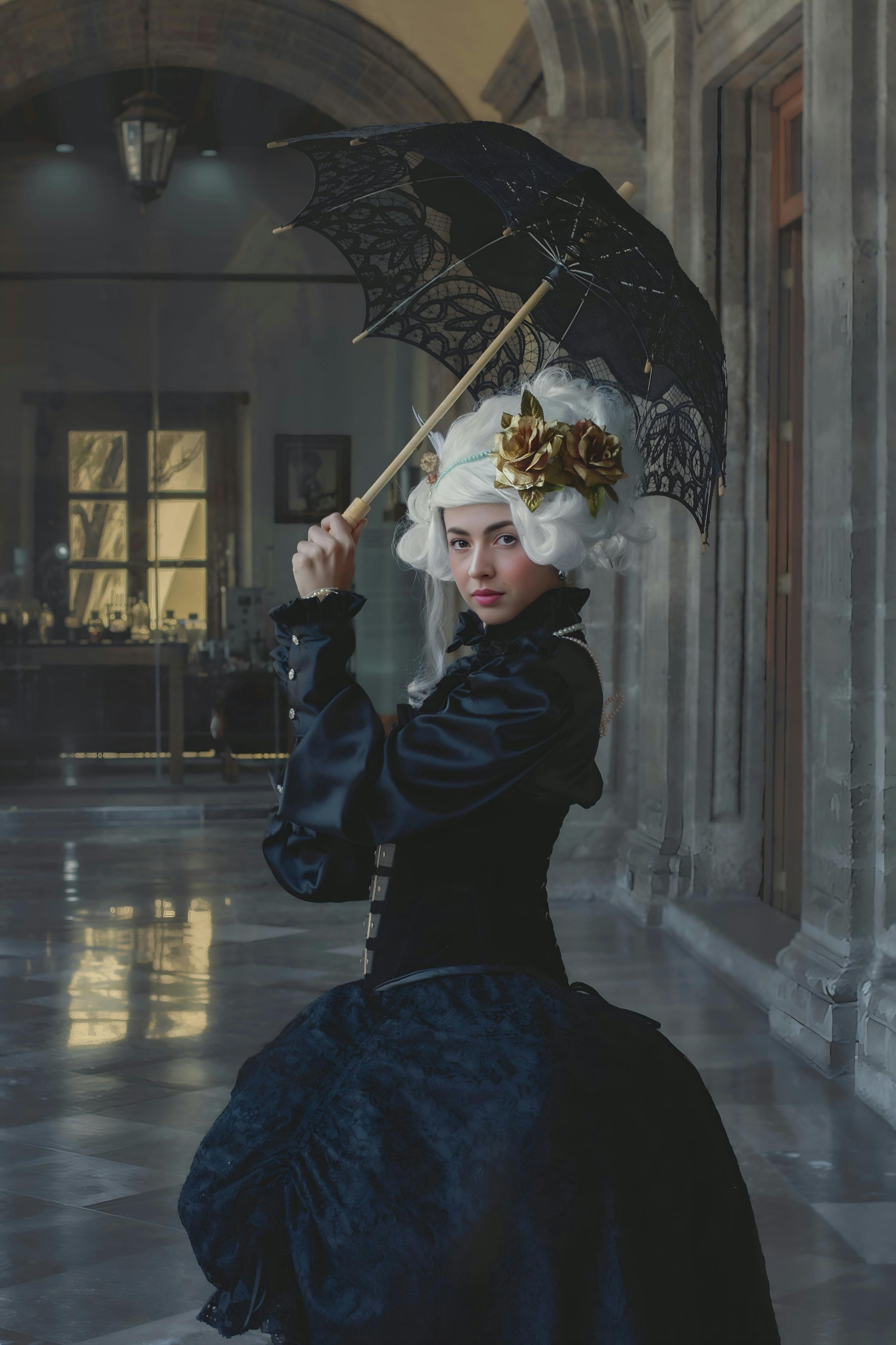 Woman in historical black dress holding an umbrella indoors, Ciudad de México