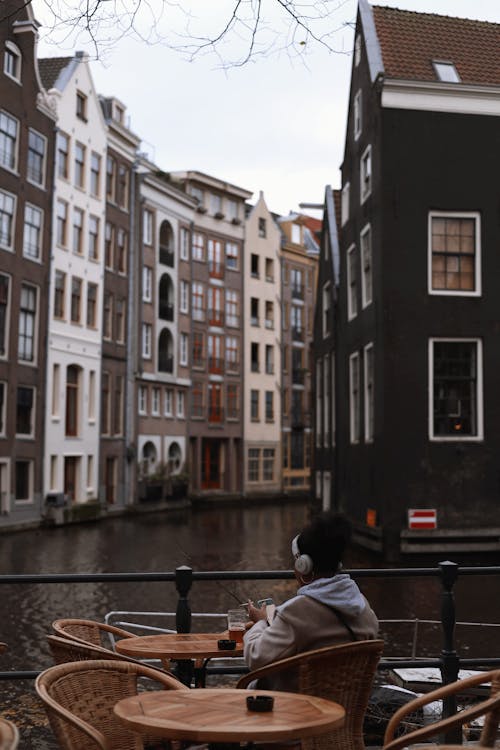A woman sitting at a table in front of a canal