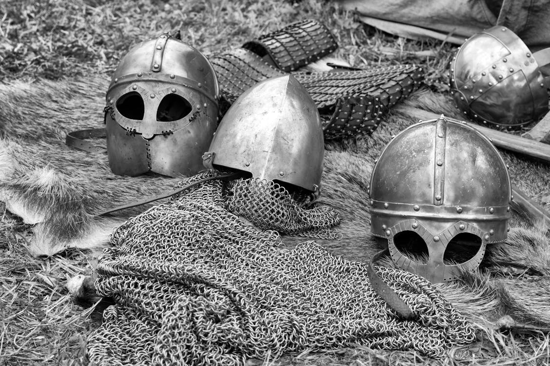 Free Grayscale Photography of Chainmails and Helmets on Ground Stock Photo
