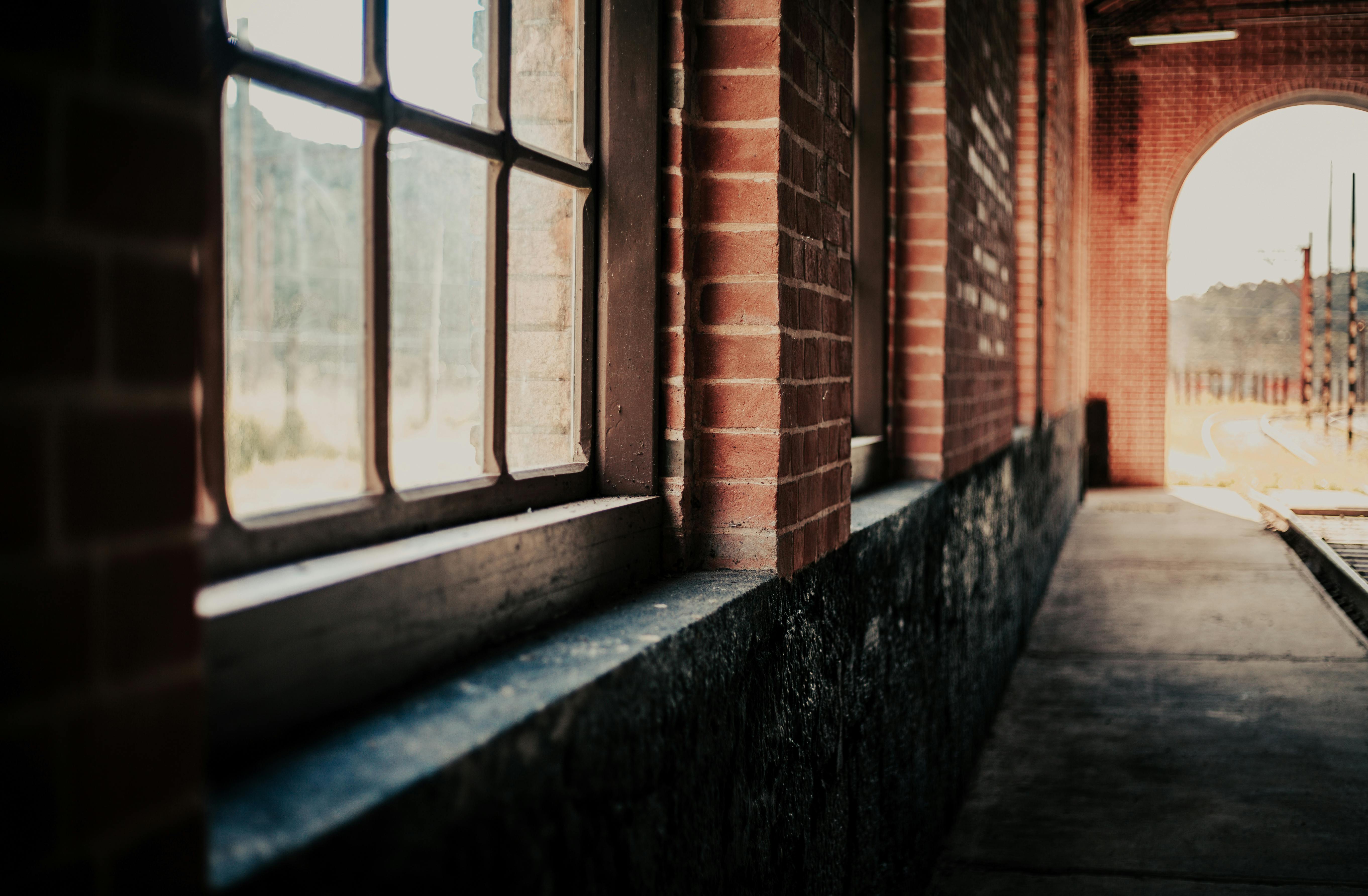 历史悠久的火车站内，有一条带有砖墙和大窗户的乡村走廊