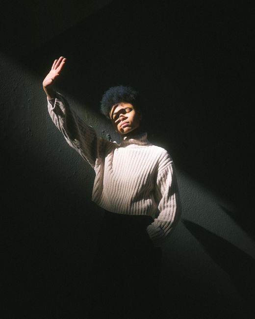 A striking portrait of a woman in textured light, casting deep shadows on the wall.