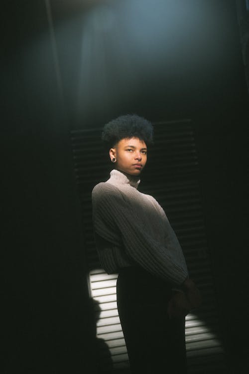 A woman with an afro standing in front of a light