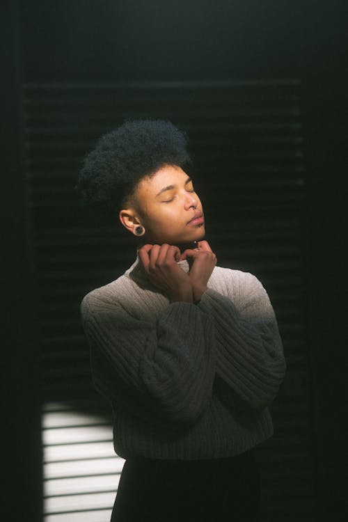 A young man with an afro wearing a sweater