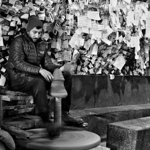 A man sitting on a bench in front of a wall of notes