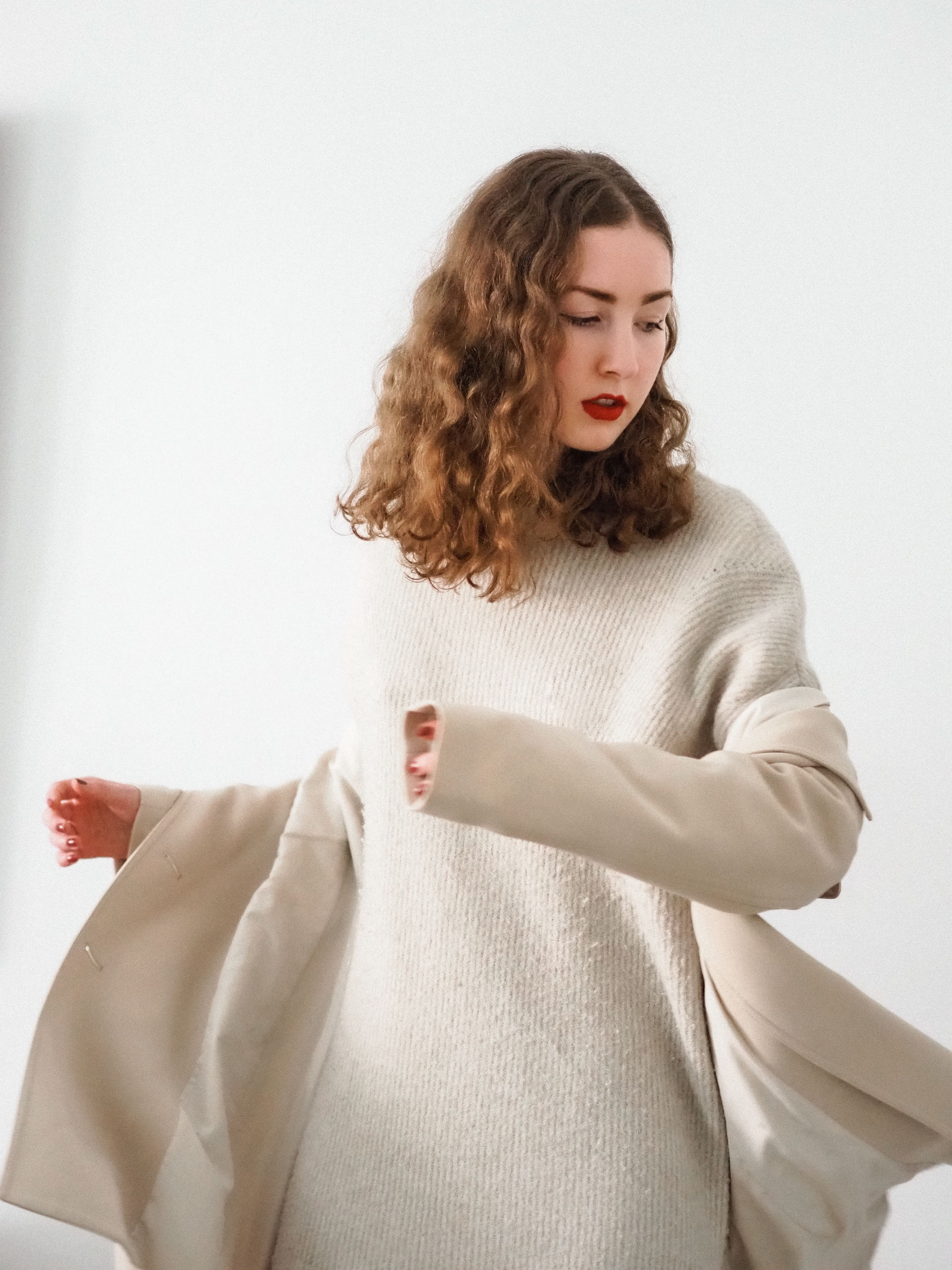 Woman wearing an oversized sweater dress with a wool coat