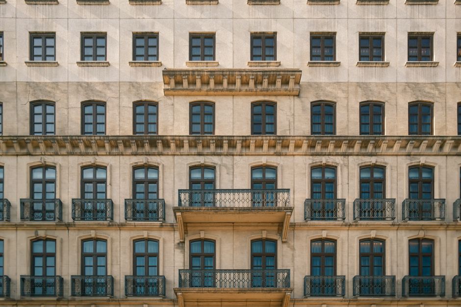 Vista detallada de una fachada urbana clásica con balcones y ventanas a la luz del día.