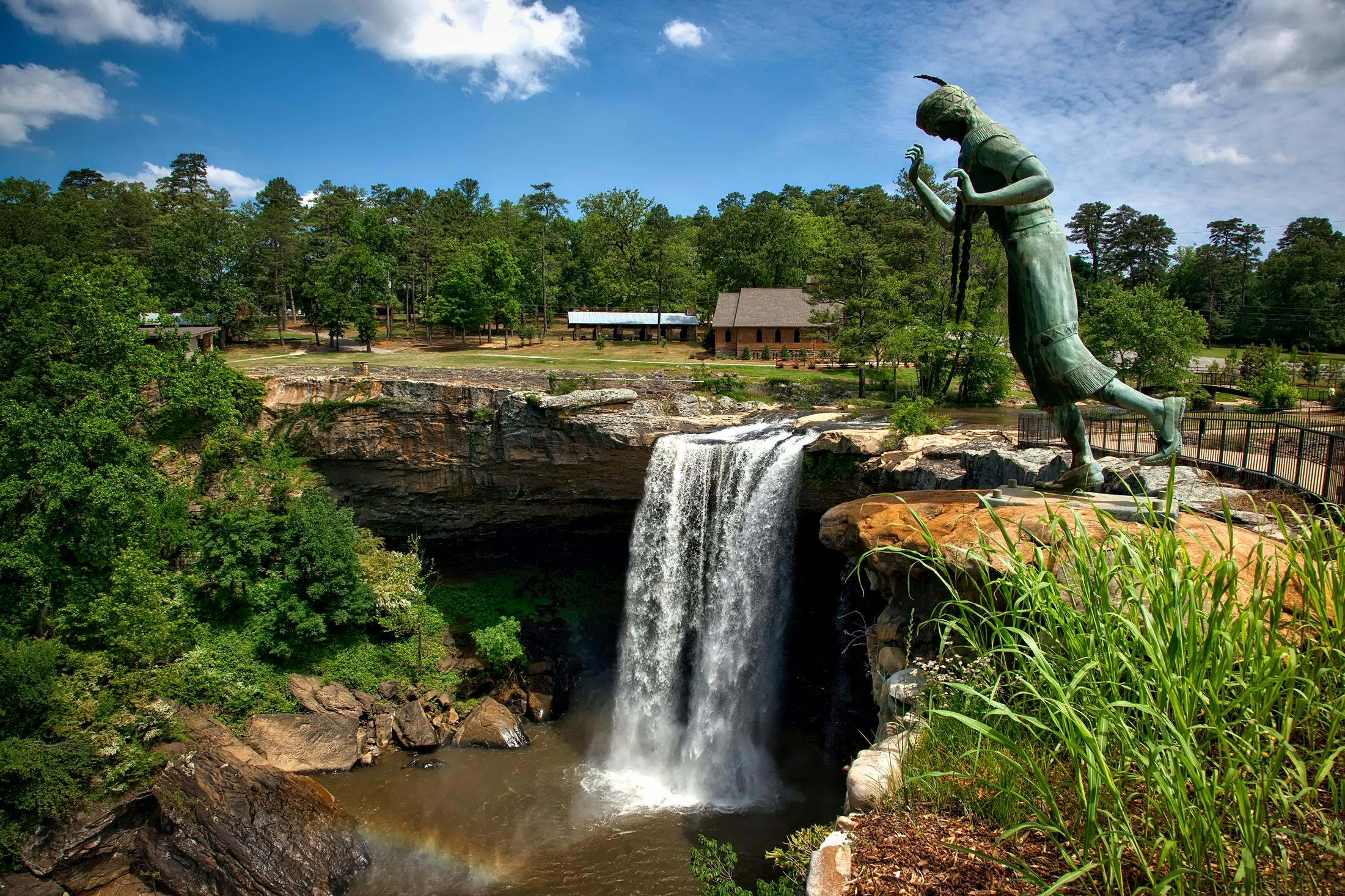Waterfall next to a large green statue in Alabama.