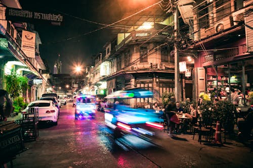 A city street at night with cars and motorcycles