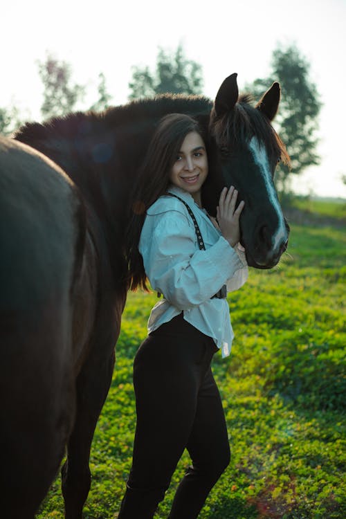 A woman is standing next to a horse