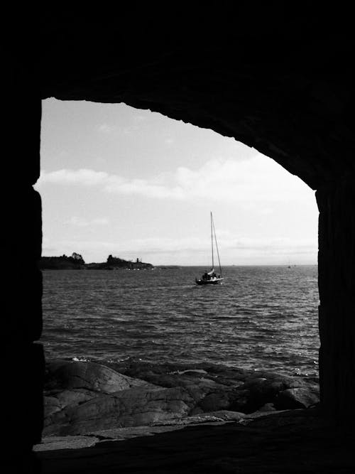 A black and white photo of a sailboat in the water