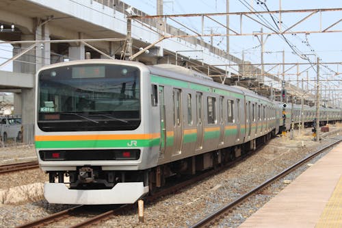 A train is traveling down the tracks at a station