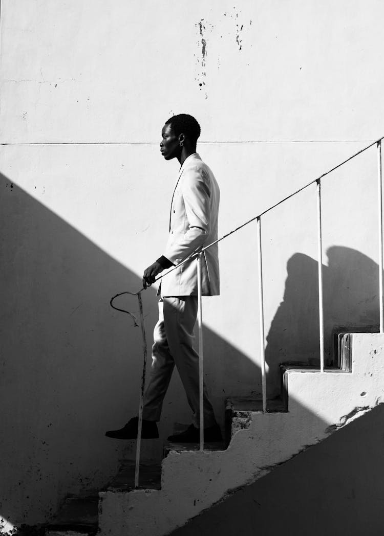 Black And White Photo Of A Man Walking Down The Stairs 