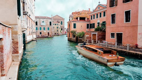 Free Orange Powerboat Between Medium Rise Buildings Stock Photo