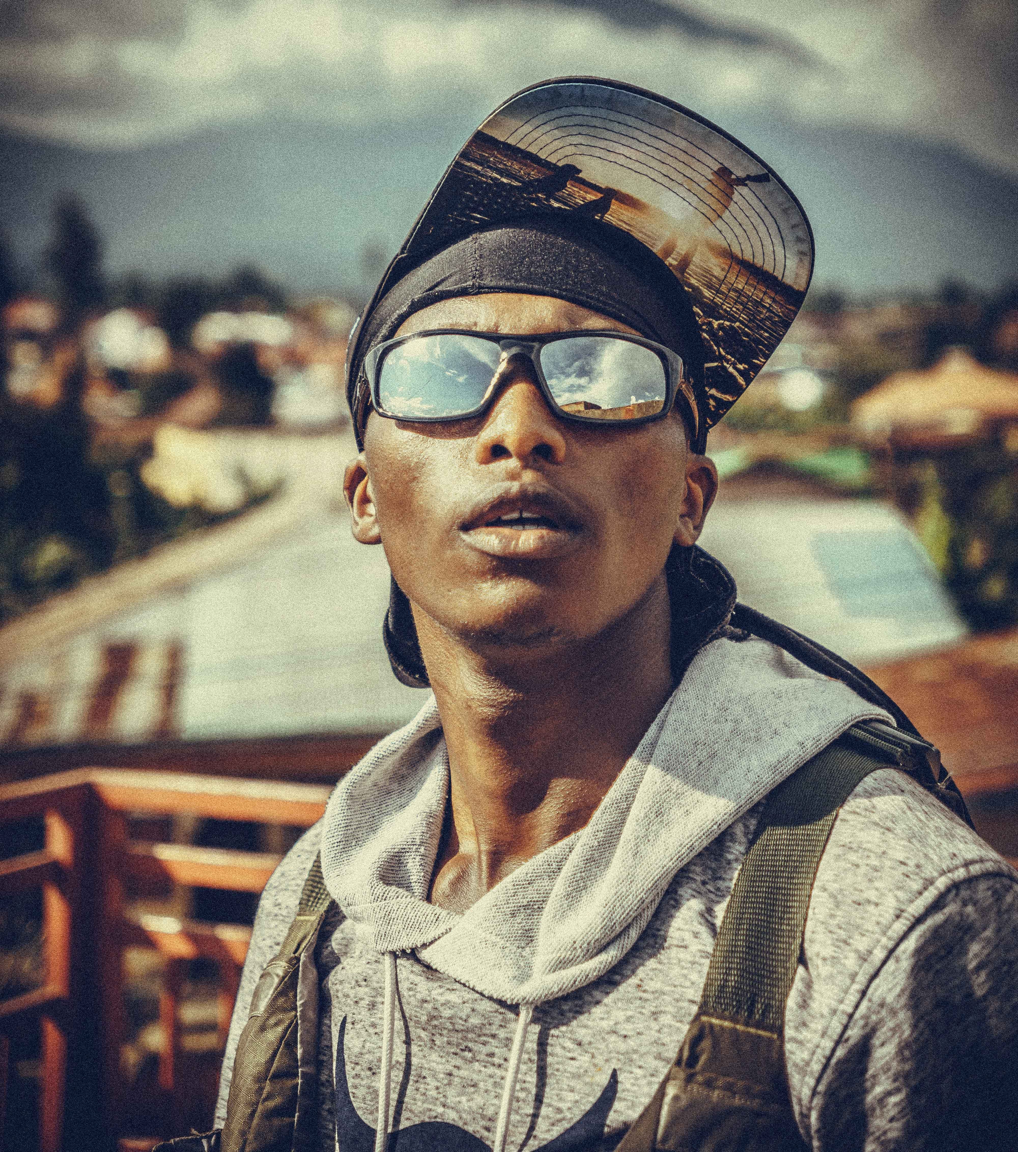 Fashionable young man wearing sunglasses and a hoodie in an urban outdoor setting. Cool vibes.