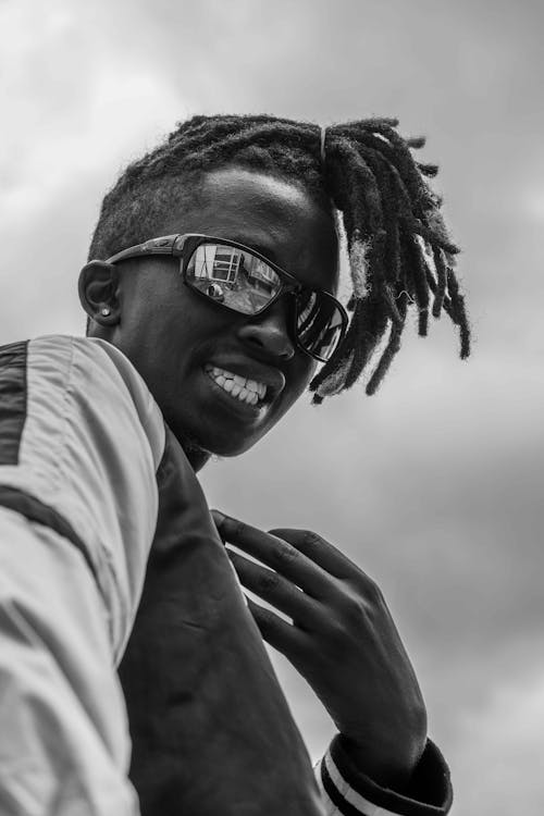 A black and white photo of a young man with dreadlocks