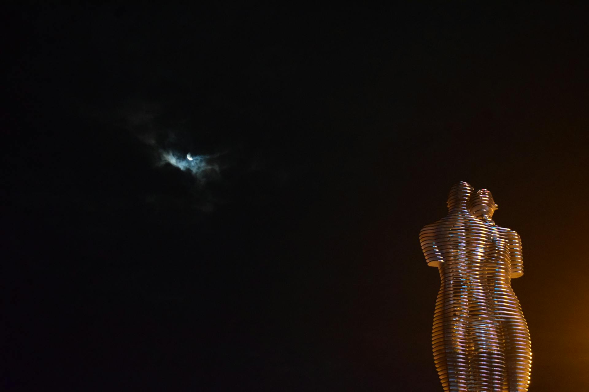 The iconic Ali and Nino sculpture in Batumi, Georgia, illuminated against the night sky.