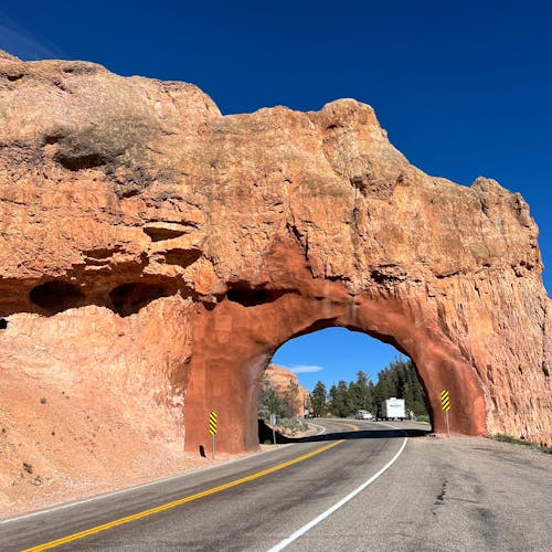 A road with a tunnel in the middle of a rock formation
