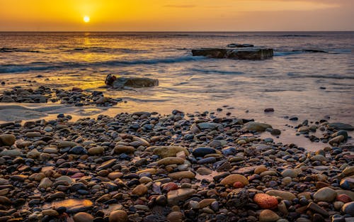 Stones on Sea Shore at Sunset