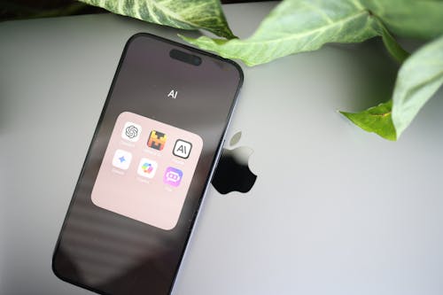 A close up of an apple iphone with a green plant